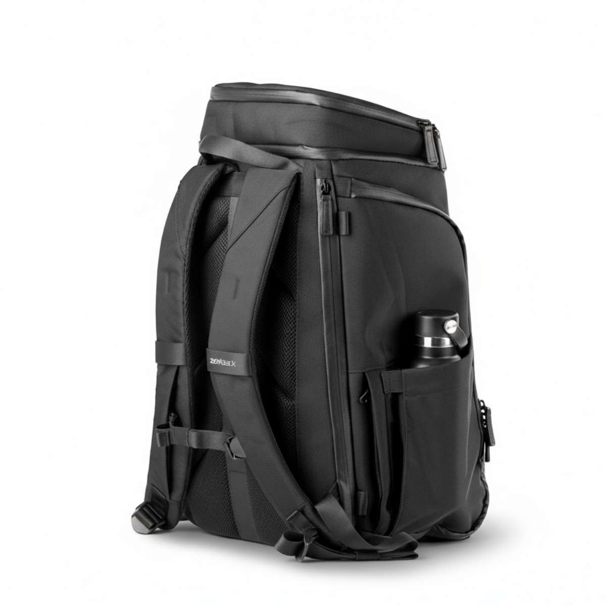 En svart ryggsäck sedd från sidan med stängda fack, vattenflaska i sidficka.