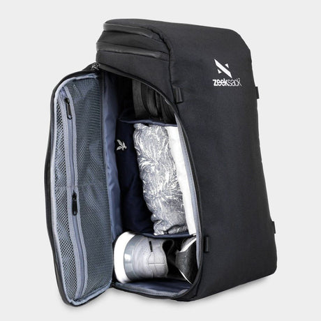 En svart ryggsäck som är öppnad från sidan, fylld med skor och kläder.